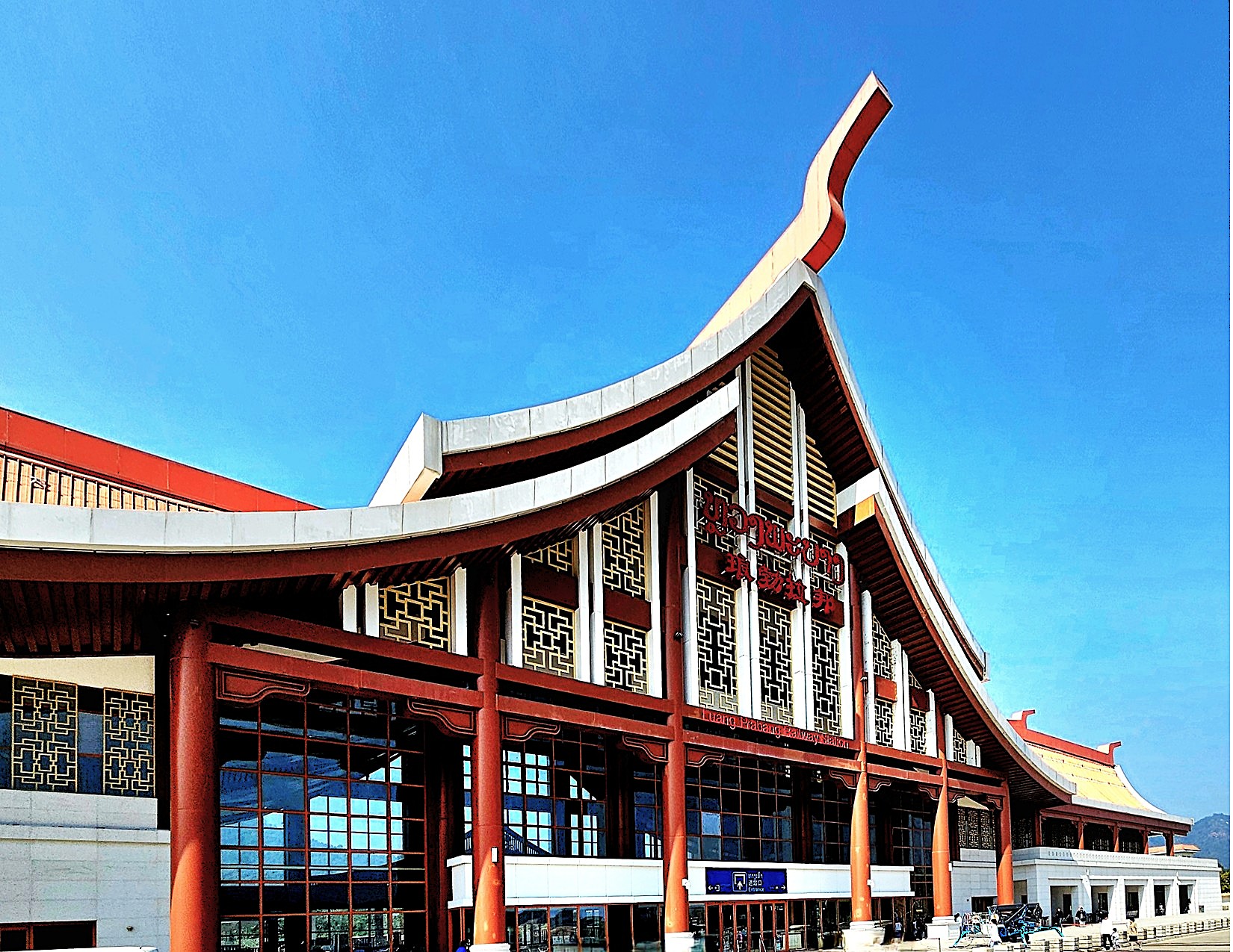 A view of the Luang Prabang railway station, showcasing a blend of traditional Lao architecture and modern design elements under a clear blue sky.