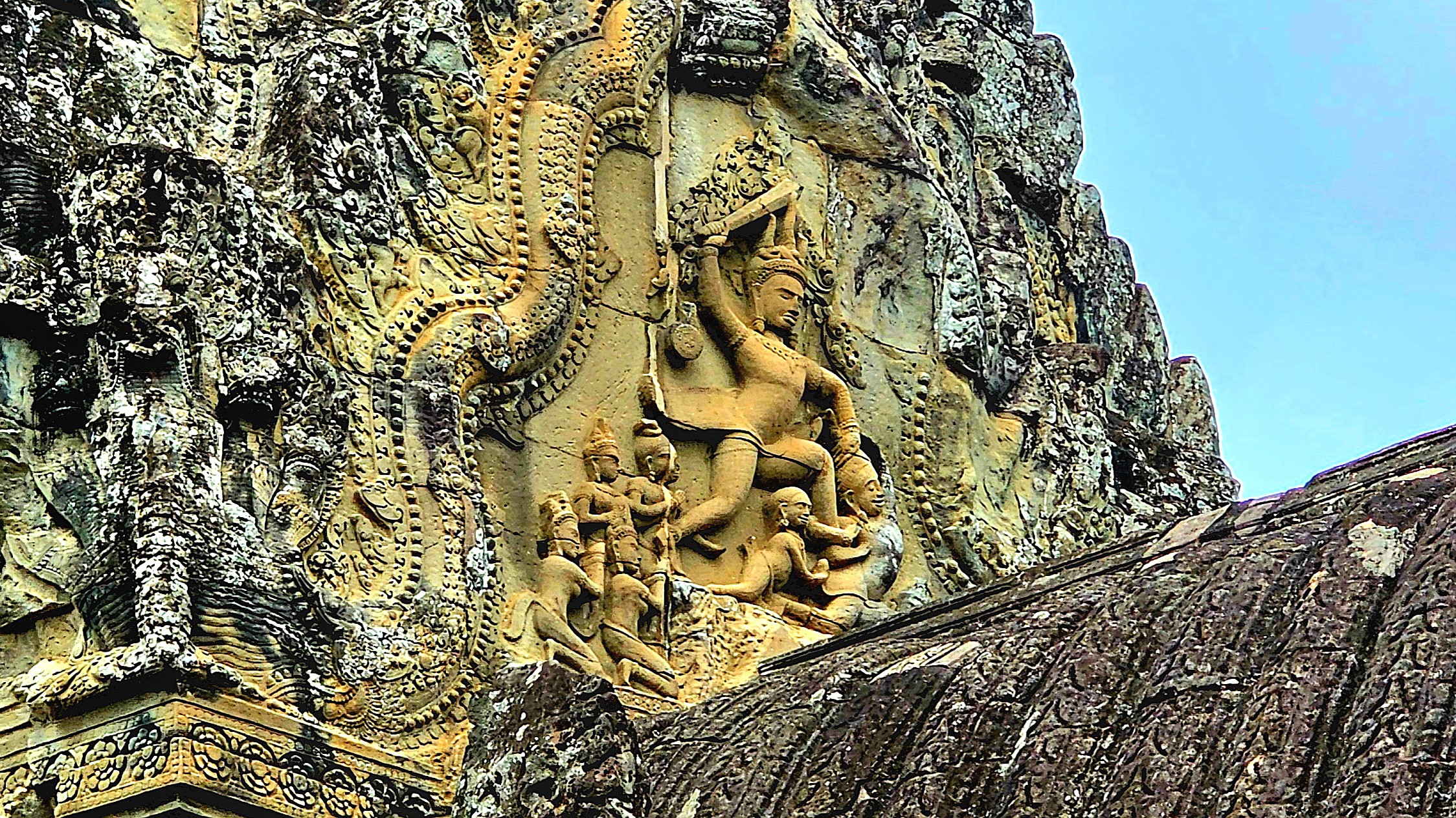 Intricate bas-relief carvings showcasing historical and mythological figures from Khmer culture on a temple wall in Angkor, Cambodia.