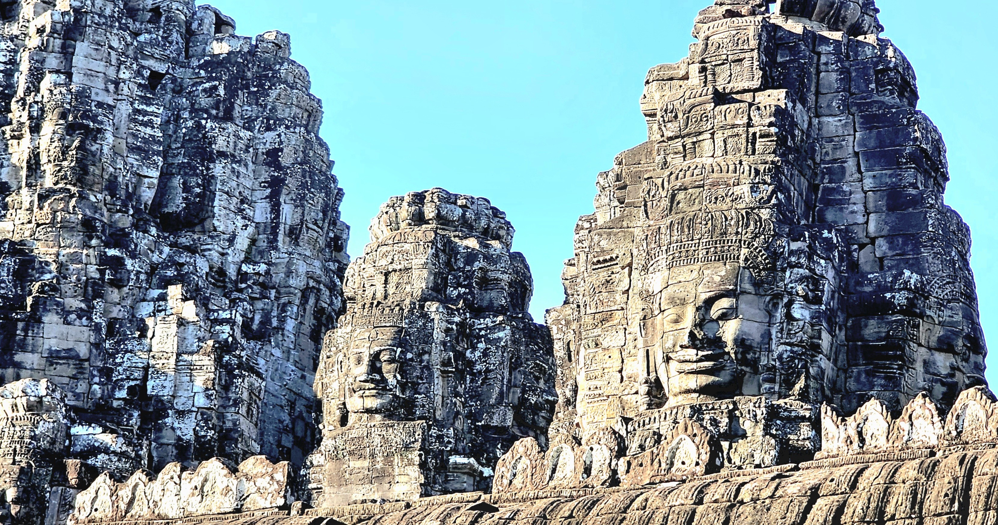 Close-up view of the stone faces and towers of Bayon Temple, showcasing intricate carvings and the unique architectural features of this historical site.